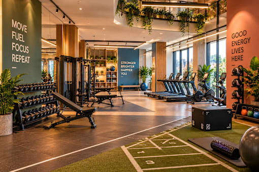 A gym with a green carpet and a sign that says "Good energy lives here".