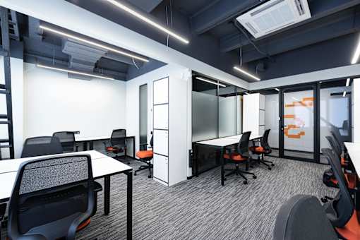 A modern office space with black chairs and white desks.