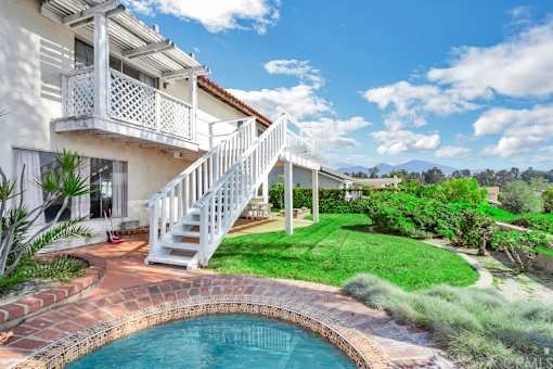 A white house with a pool in the backyard.