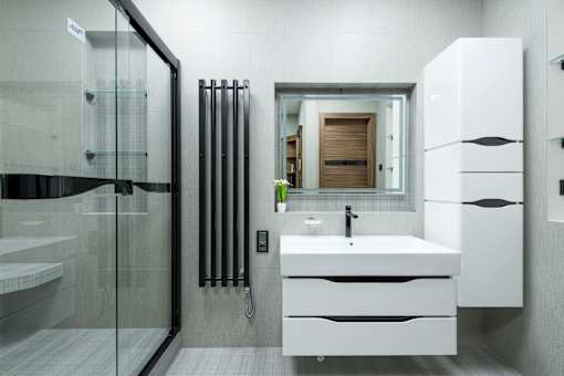 A modern bathroom with a white sink and a glass shower.