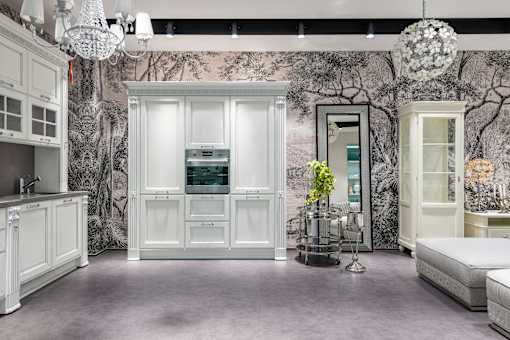 A room with a large white wardrobe and a bed.
