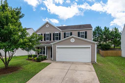 A house with a grey roof and a white garage door.