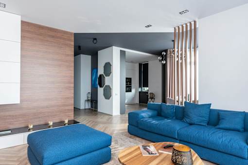 A blue couch is in the middle of a modern living room.