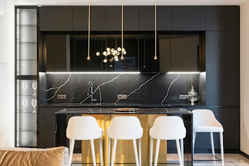 A modern kitchen with a marble backsplash and white chairs.
