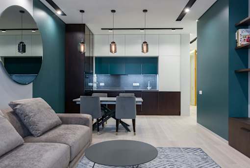 A modern living room with a grey sofa and a round table.