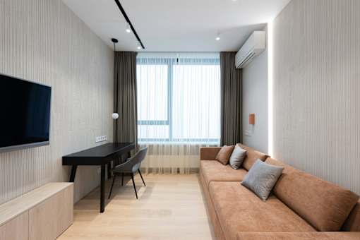 A living room with a brown couch, a black table, and a television.