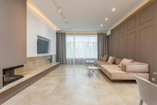 A modern living room with a fireplace and a large couch.