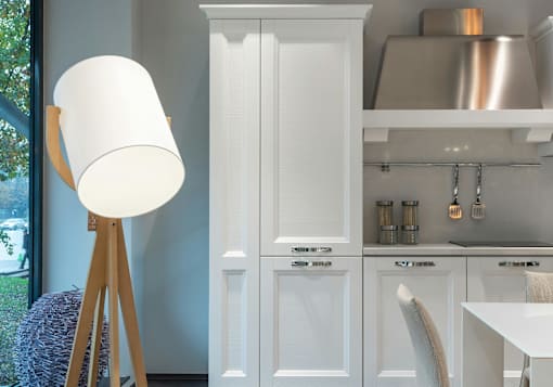 A white lamp stands next to a white cabinet in a kitchen.