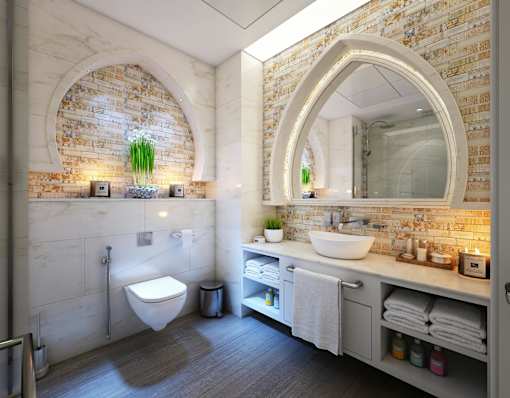 A bathroom with a toilet, sink, and mirror.