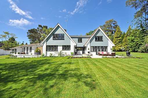 A large house with a green lawn in front.