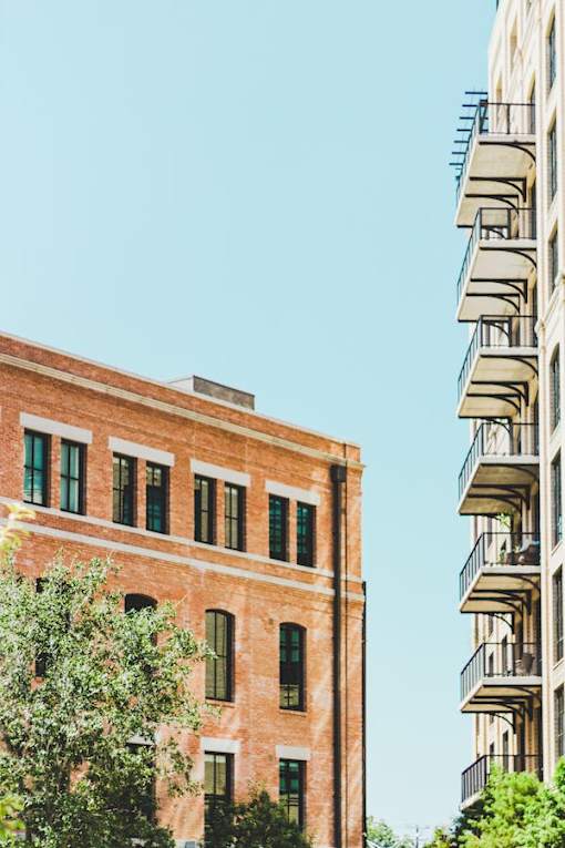 A red brick building with green trees in front.