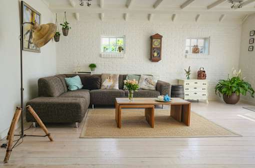 A living room with a grey couch, a wooden coffee table, and a white chair.