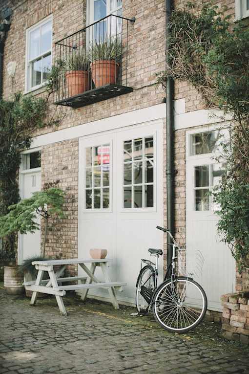 a bicycle and picnic table in front of a brick building