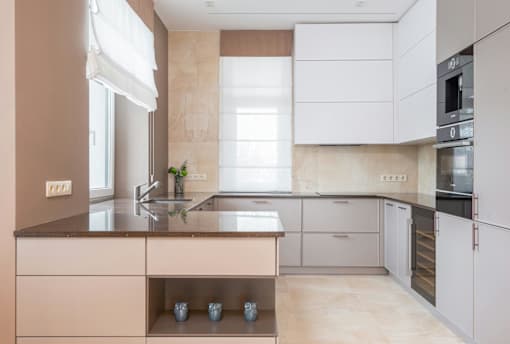 A modern kitchen with a sink, stove, and refrigerator.