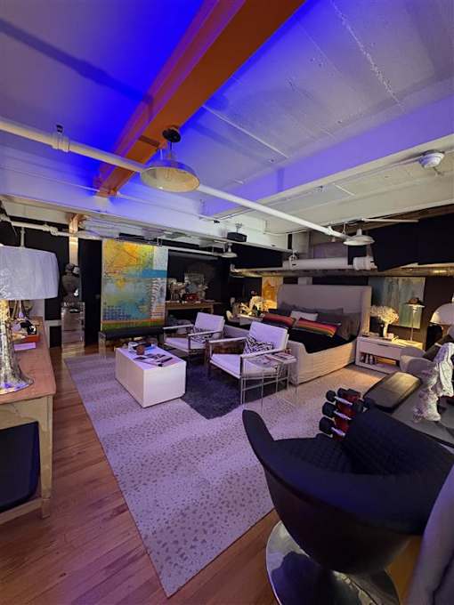 A modern living room with a black chair in the foreground.