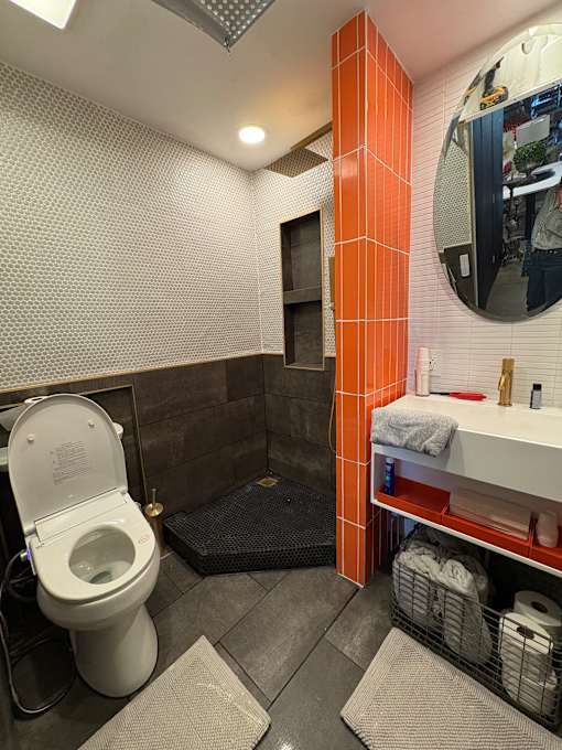 A bathroom with a toilet and a mirror.