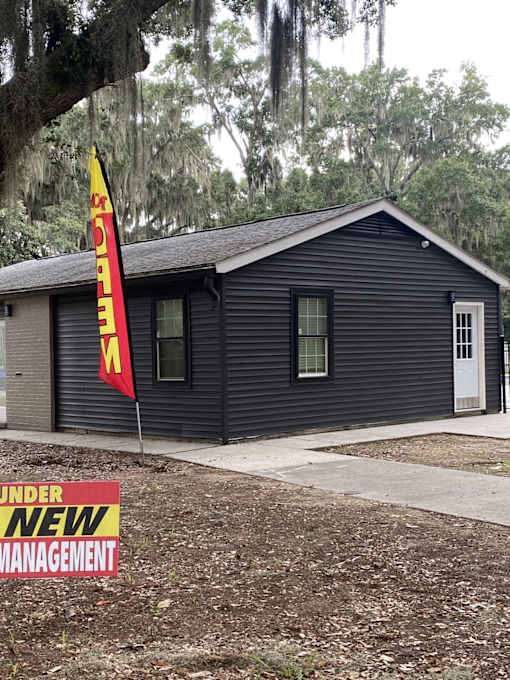 A small black house with a red and yellow flag in front of it.