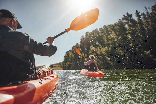 a man and a woman in kayaks on a river