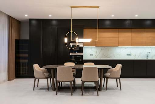 A modern dining room with a marble backsplash and a round pendant light.