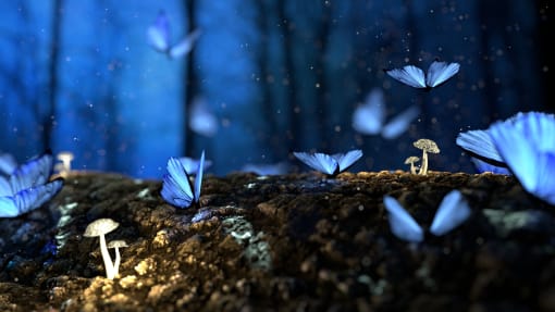a group of blue butterflies flying in the dark