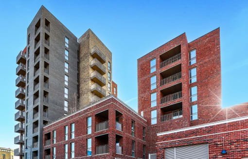 two brick apartment buildings against a blue sky