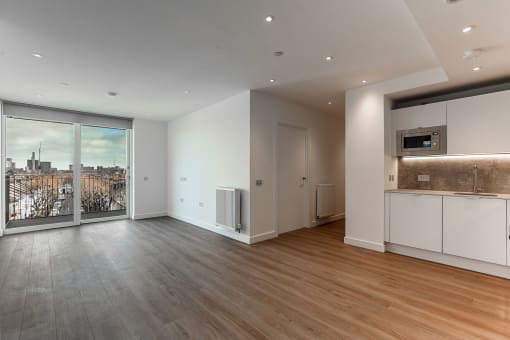 a living room with a large window and a kitchen