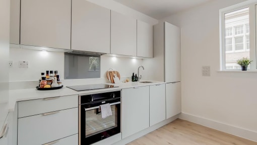 a kitchen with white cabinets and a stove and a sink