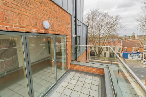 a balcony with a brick wall and glass doors