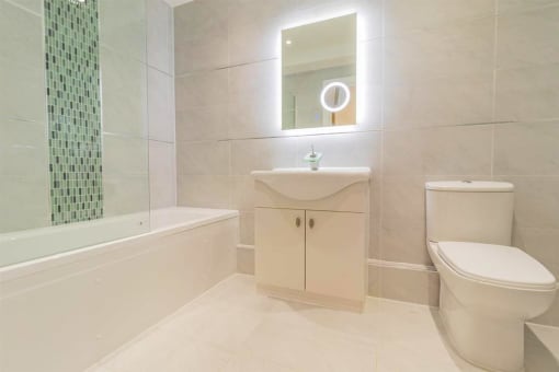 a bathroom with a toilet and a sink and a bath tub