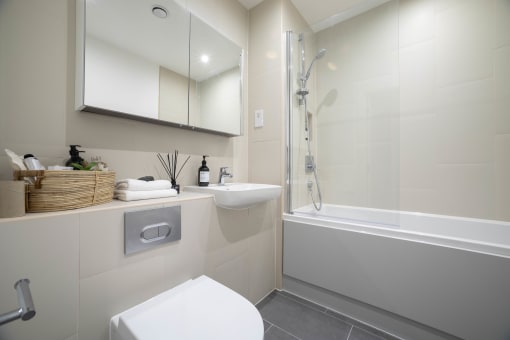 a white bathroom with a shower and a sink and a toilet