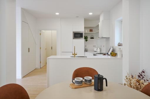 a kitchen with white walls and white countertops and a white island with a white countertop