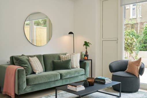 a living room with a green couch and a blue chair