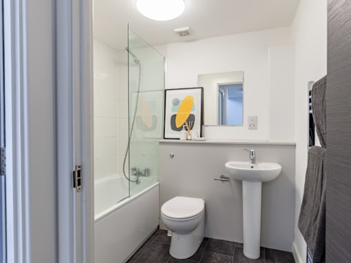 A white toilet sits next to a sink in a bathroom.