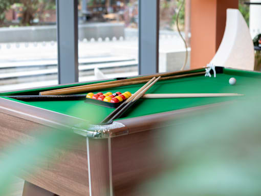 A pool table with a green cloth and a white cue ball.