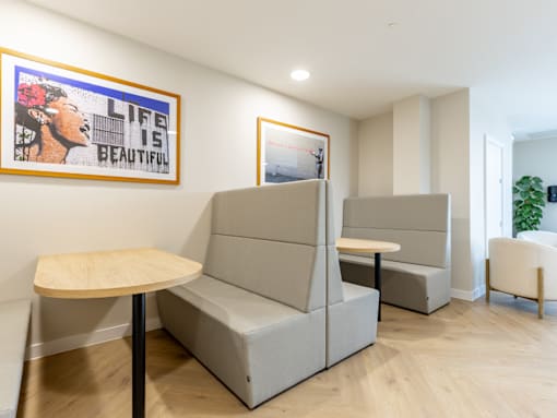 A room with a grey sofa and a wooden table.