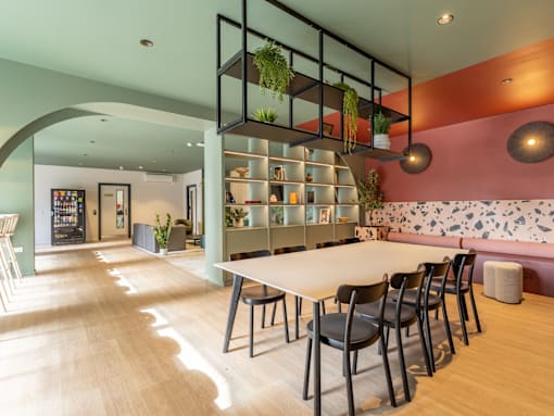 A modern dining area with a long table and chairs.