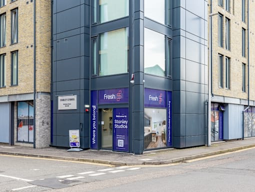 A building with a purple sign that says Fresh on it.