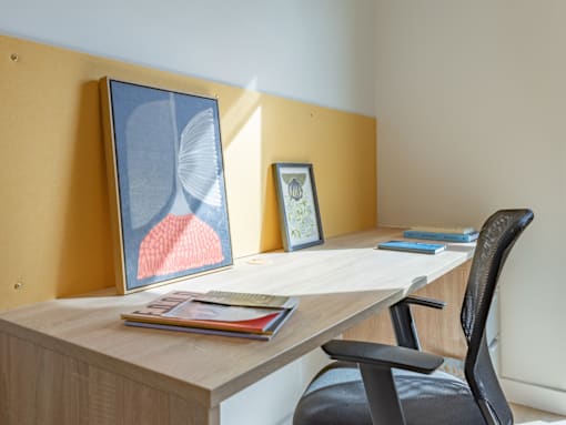 A desk with a chair and two picture frames on it.