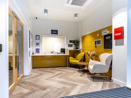 A reception area with a yellow counter and chairs.