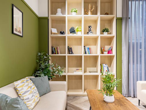 A living room with a couch, a coffee table, and a bookshelf filled with books and decorative items.
