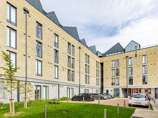 A large building with a parking lot in front.