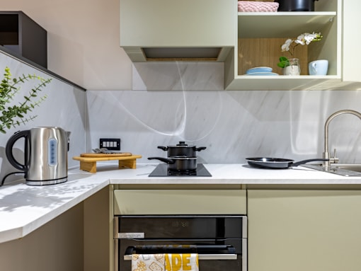 A modern kitchen with a stove, oven, and a coffee maker.