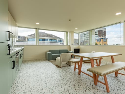 A kitchen with a table and chairs in front of a window.