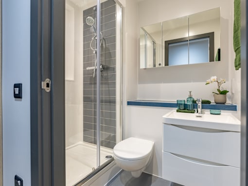 A modern bathroom with a toilet, sink, and shower.