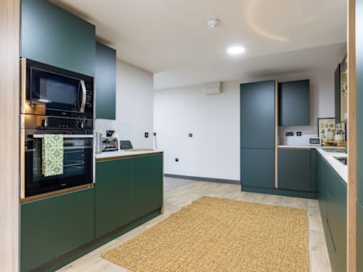 A kitchen with green cabinets and a microwave oven.