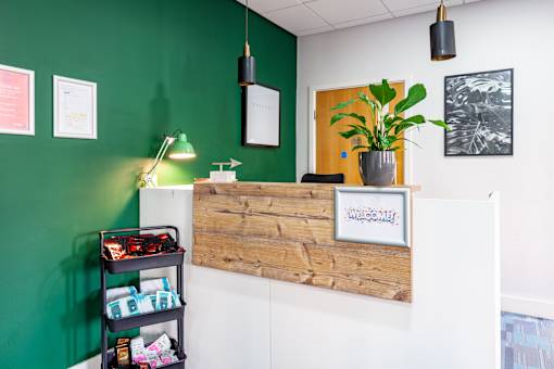 A reception desk with a wooden top and a sign that says "Welcome" on it.