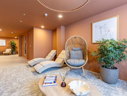 A living room with a chair, a table, and a plant.