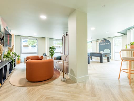 A living room with a large orange chair in the center.