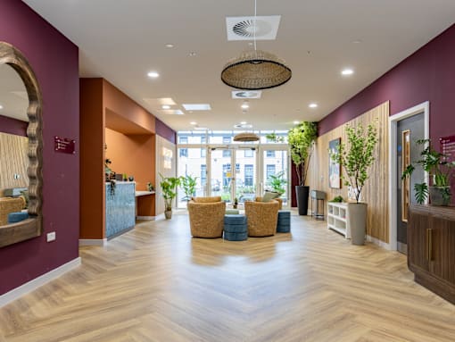 A large room with a wooden floor and a hanging light fixture.