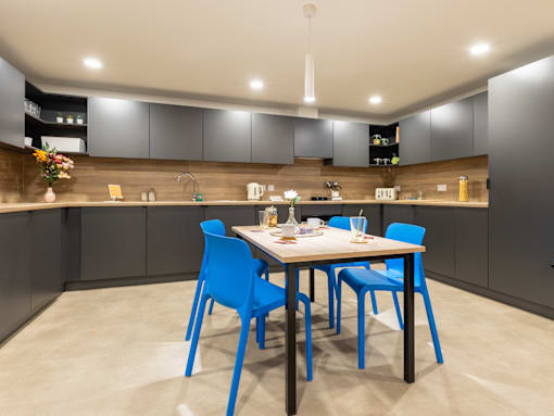 A kitchen with a table and chairs.